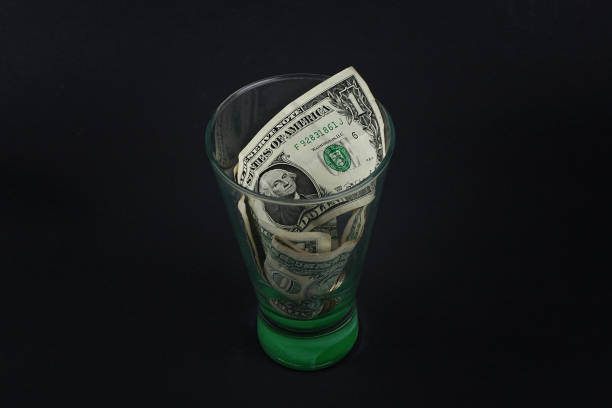 istock Dollar in a glass jar on black background 1127523159