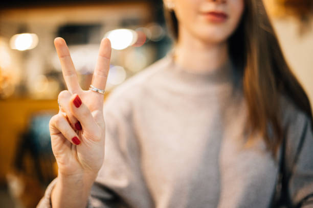 istock Young woman making victory sign 1127524422