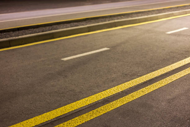 istock Wide bright double yellow marking sign line along modern wide smooth empty asphalt highway street stretching to horizon. Speed, safety, comfortable journey and professional road building concept. 1127524524