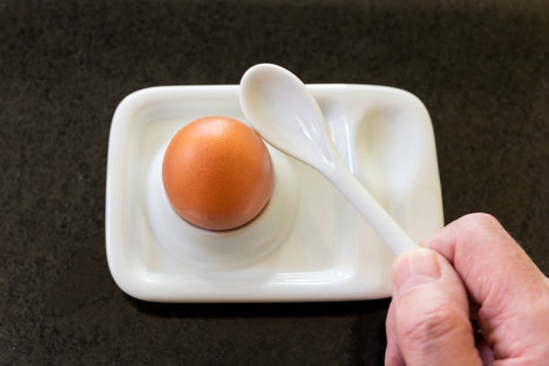 istock Spoon in hand about to break the top off a freshly prepared boiled egg. 1127524836