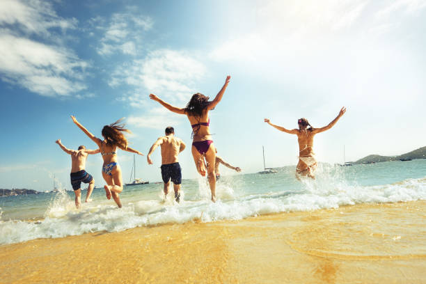 istock Big group friends beach run vacations 1127526912
