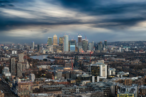 Moody view to Canary Wharf, London, UK; stormy clouds over the financial center for brexit times
