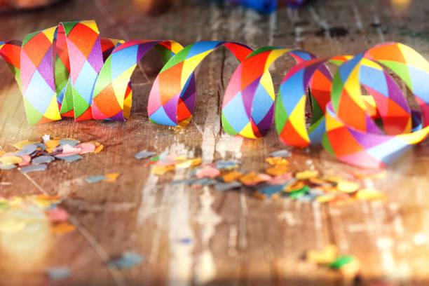 Colorful confetti and streamers with bokeh on old shabby wood for a carnival bachground