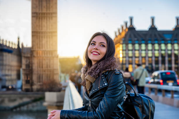 weibliche londoner reisende genießt den blick neben dem big ben uhrturm - journey elegance people traveling architecture stock-fotos und bilder