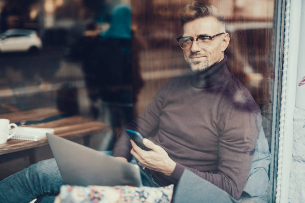 istock Cheerful man sitting in cafe and smiling 1127532170