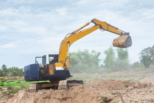istock Yellow excavator machine working earth moving works at construction site 1127533014