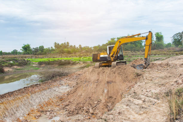 istock Yellow excavator machine working earth moving works at construction site 1127533746