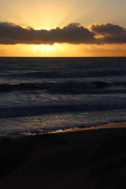 istock Sunrise over waves and beach 1127533960
