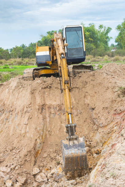 macchina per escavatori gialli che lavora lavori di movimento della terra in cantiere - construction equipment earth mover hydraulic platform cylinder foto e immagini stock