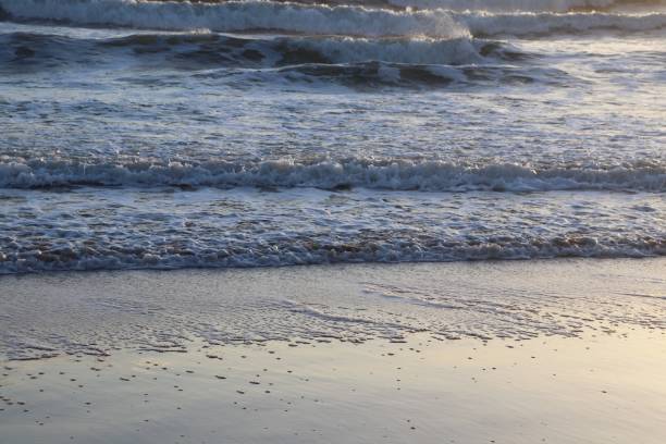 istock Sunrise over waves and beach 1127535684