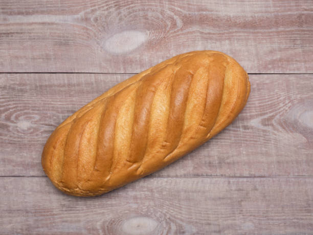 istock Loaf of bread on a light brown wooden background 1127536346