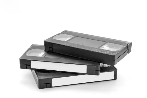 Photo of Three old videocassette cartridges on white background.