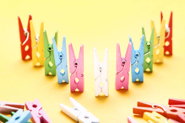 istock Colorful clothespins on yellow background 1127536637