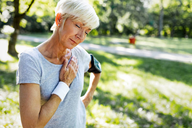 胸の痛みがジョギング中に心臓発作で苦しんでいると年配の女性 - human cardiovascular system 写真 ストックフォトと画像