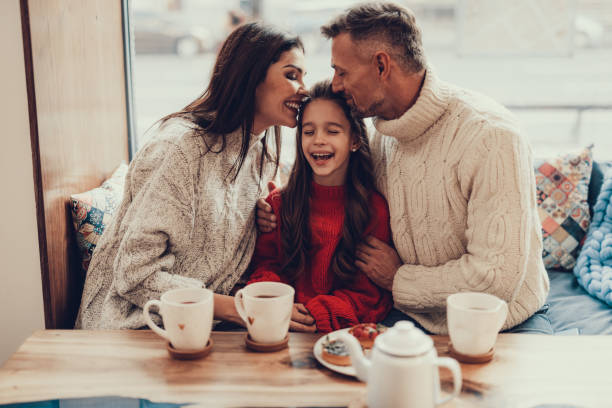istock Two kind parents kissing they small daughter 1127536703