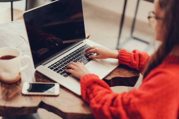 istock Young girl using laptop and sitting in cafe 1127536727