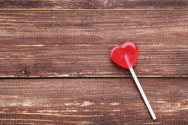 istock Heart shaped lollipop on brown wooden table 1127538641