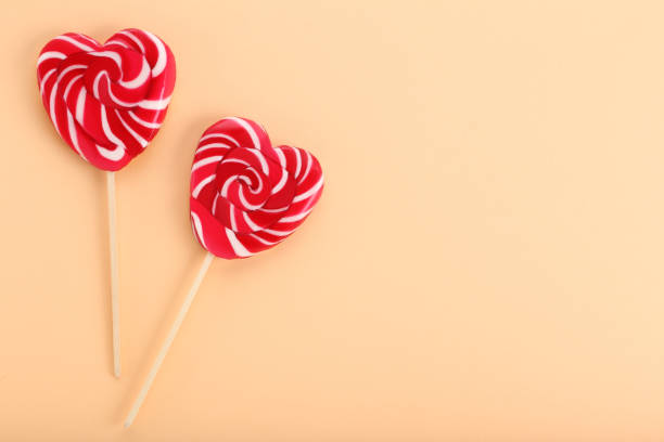 istock Heart shaped lollipops on beige background 1127538662