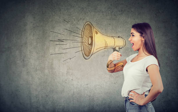 Young woman screaming into loudspeaker