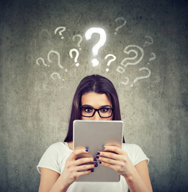 istock shocked woman looking at tablet computer has many questions 1127538714