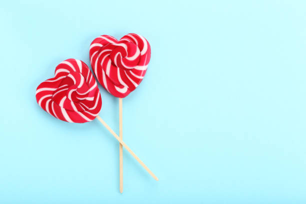 istock Heart shaped lollipops on blue background 1127538729