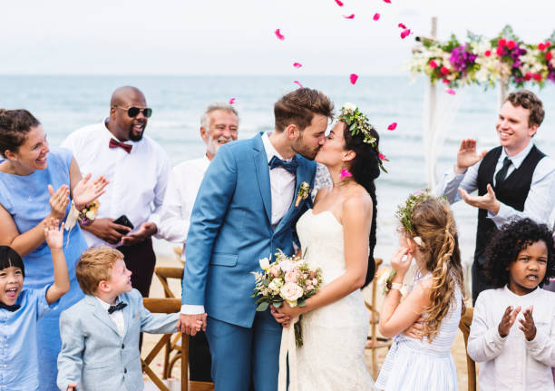 joven pareja besándose en la recepción de la boda - boda playa fotografías e imágenes de stock