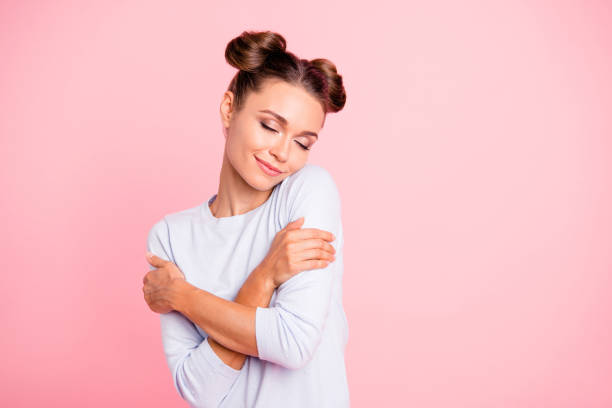 Portrait of nice-looking sweet lovable attractive winsome fascinating well-groomed lovely calm peaceful cheery girl hugging herself isolated over pink pastel background Portrait of nice-looking sweet lovable attractive winsome fascinating well-groomed lovely calm peaceful cheery girl hugging herself isolated over pink pastel background topknot stock pictures, royalty-free photos & images