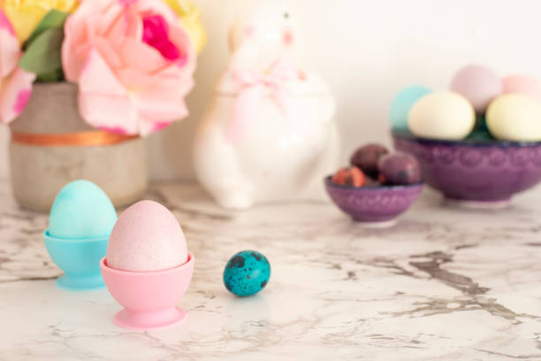 istock Easter eggs. Colorful eggs in matte colors. Chicken egg standing in the egg cup. Light marble background 1127540393