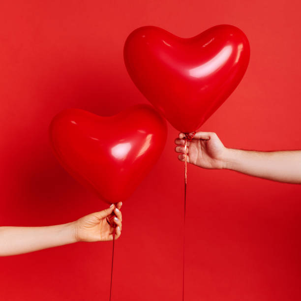 istock Hand holding a red heart balloon 1127540530