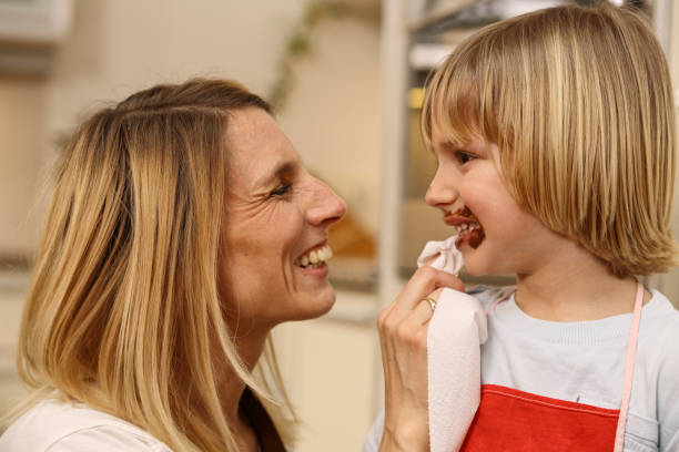 istock Mother wiping chocolate from her son's mouth 1127541501