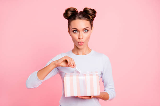 retrato de su agradable atractiva encantadora dulce winsome alegre alegre chica glamour en manos abrir la caja de la cinta de arco aislada sobre fondo rosa pastel - surprise child little girls shock fotografías e imágenes de stock