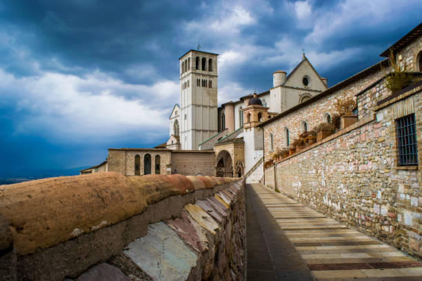 Panorama of the ancient medieval city of Assisi with the Basilica of San Francesco d'Assisi and the bell tower on a rainy day Panorama of the ancient medieval city of Assisi with the Basilica of San Francesco d'Assisi and the bell tower on a rainy day cielo minaccioso stock pictures, royalty-free photos & images