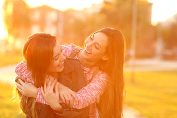 istock Two funny friends meeting and cuddling in a park 1127542253