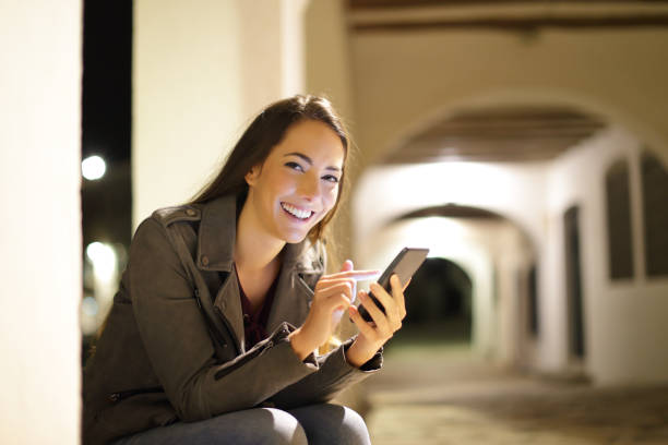 istock Woman using phone in the night looks at camera 1127542277