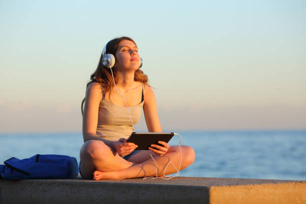 istock Student relaxing listening to music from tablet 1127542336