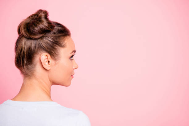 Close-up profile side view of nice cute attractive groomed candid girl wearing two fashionable buns copy empty blank space place isolated over pink pastel background Close-up profile side view of nice cute attractive groomed candid girl wearing two fashionable buns copy empty blank space place isolated over pink pastel background topknot stock pictures, royalty-free photos & images