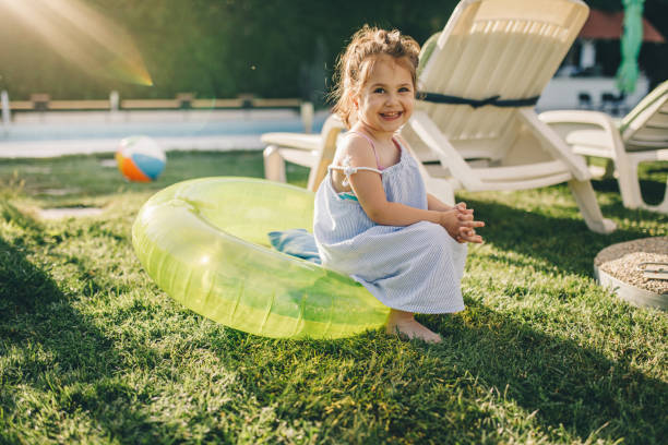 istock Smiling toddler sitting on an inflatable ring by the pool 1127542714