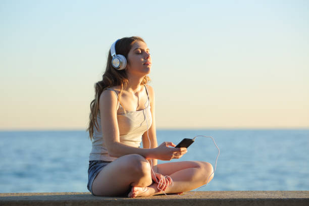 jeune fille se détendre écouter de la musique de téléphone intelligent - full song photos et images de collection