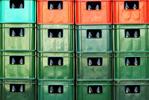 Photo of Full frame of plastic colorful beer crates stacked one upon the other