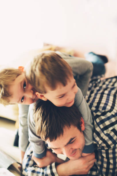 istock Kids piling on top of a father and having a really big fun. 1127546857