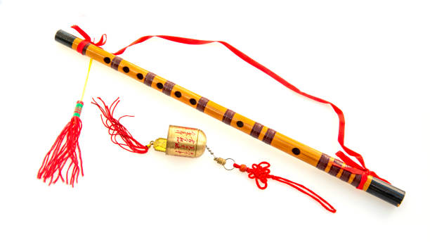 Feng shui flutes, bell and prayer flags set on a white background.