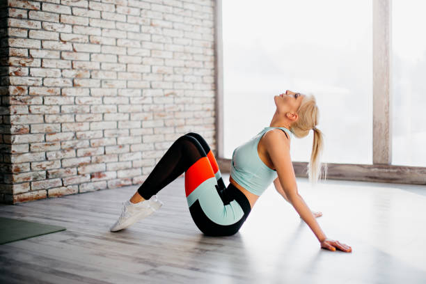 istock young athletic female sitting on floor 1127548311