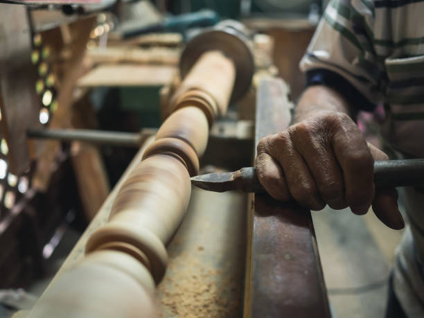istock Hands of carpenter turning wood on lathe machine in carpentry workshop 1127548315