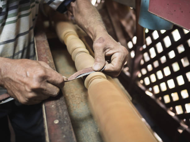 istock Hands of carpenter turning wood on lathe machine in carpentry workshop 1127548671