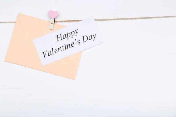 istock Inscription Happy Valentine Day with envelope on white background 1127548938