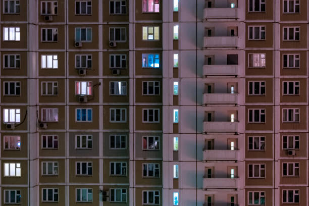 istock Facade of an apartment building with luminous windows at night 1127554840