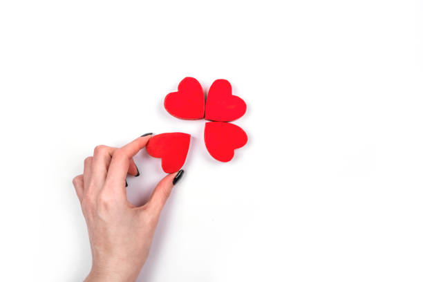 Woman hand taking small hearts on the white background.