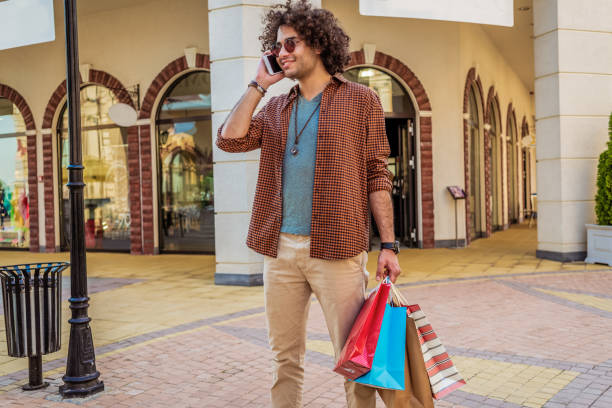 istock young man in shopping talking on the phone 1127561121