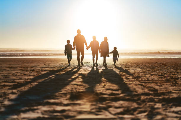 Shot of a happy young family going for a walk together along the beach