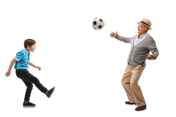 Senior man playing football with his grandson isolated on white background